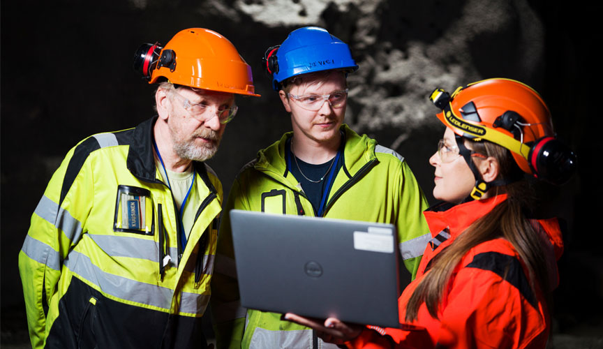 Three people wearing safety equipment in a tunnel (photo)